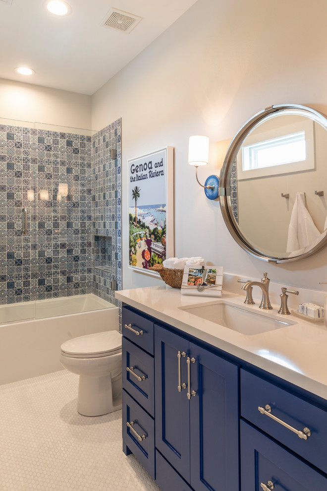 На фото: ванная комната среднего размера в морском стиле с фасадами островного типа, синими фасадами, ванной в нише, душем над ванной, раздельным унитазом, синей плиткой, цементной плиткой, серыми стенами, полом из мозаичной плитки, врезной раковиной, столешницей из кварцита, белым полом, душем с распашными дверями и белой столешницей с