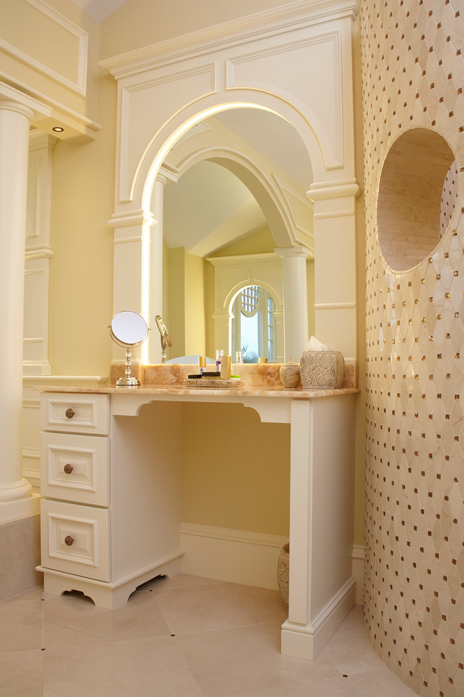 Пример оригинального дизайна: главная ванная комната среднего размера в классическом стиле с фасадами с выступающей филенкой, бежевыми фасадами, ванной на ножках, угловым душем, унитазом-моноблоком, бежевой плиткой, мраморной плиткой, желтыми стенами, мраморным полом, врезной раковиной, столешницей из оникса, бежевым полом и открытым душем