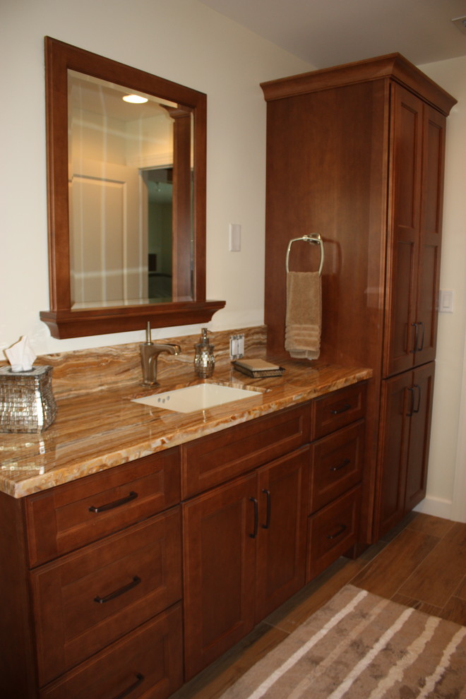 Example of a mid-sized island style kids' porcelain tile bathroom design in Miami with shaker cabinets, brown cabinets, beige walls, an undermount sink, onyx countertops and brown countertops