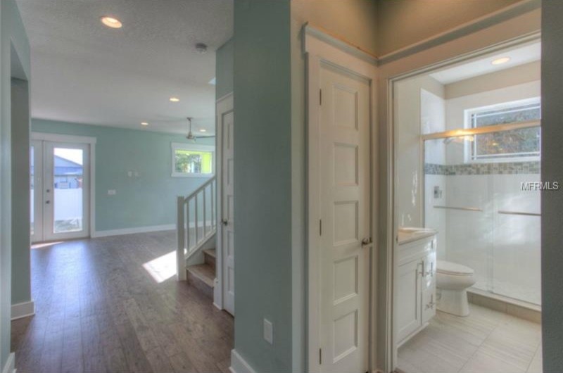 На фото: ванная комната в морском стиле с врезной раковиной, фасадами в стиле шейкер, белыми фасадами, столешницей из оникса, открытым душем, унитазом-моноблоком, синей плиткой, стеклянной плиткой, серыми стенами и полом из керамической плитки