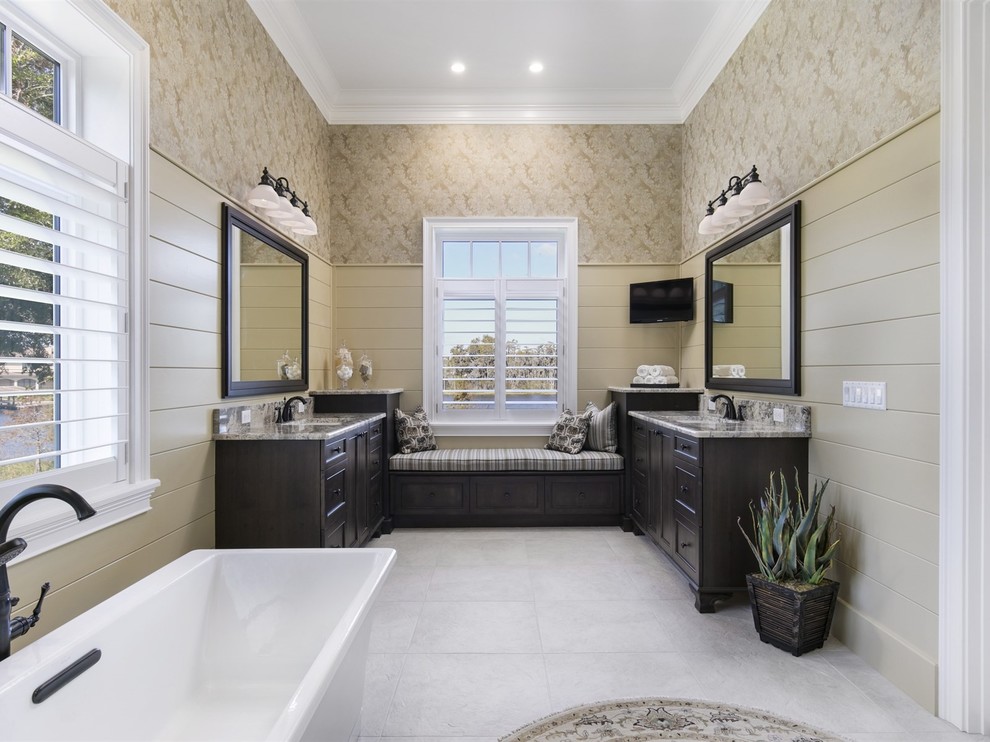 Design ideas for a large nautical ensuite bathroom in Orlando with dark wood cabinets, a freestanding bath, beige walls, a submerged sink, shaker cabinets, a corner shower, ceramic flooring, beige floors and a hinged door.
