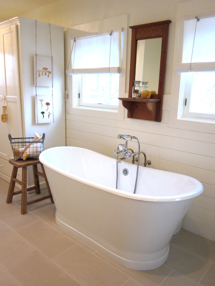 Inredning av ett shabby chic-inspirerat badrum, med ett fristående badkar och beige kakel