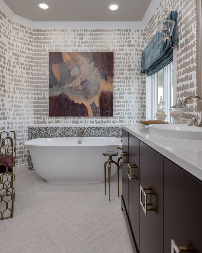 На фото: ванная комната в стиле неоклассика (современная классика) с плоскими фасадами, темными деревянными фасадами, отдельно стоящей ванной, бежевыми стенами, накладной раковиной, серым полом, белой столешницей и обоями на стенах