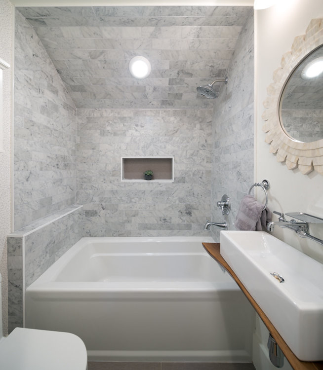 Exempel på ett litet maritimt badrum för barn, med vita skåp, ett badkar i en alkov, en dusch/badkar-kombination, en toalettstol med hel cisternkåpa, grå kakel, marmorkakel, vita väggar, klinkergolv i porslin, ett fristående handfat, träbänkskiva, grått golv och med dusch som är öppen