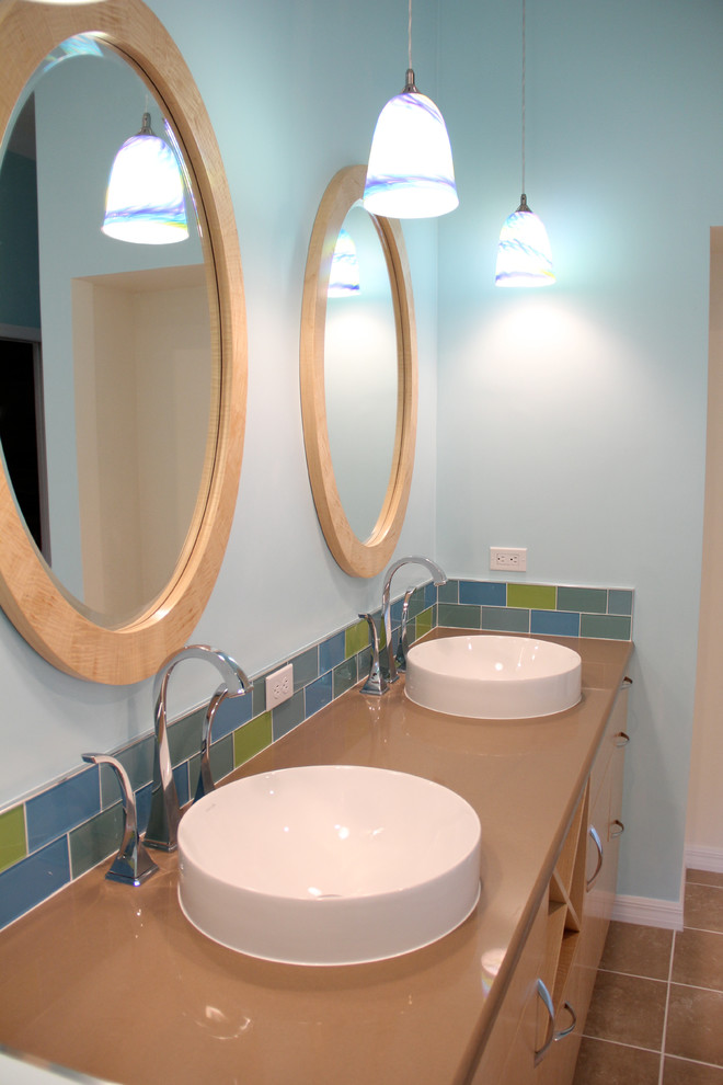 Cette image montre une salle de bain principale marine en bois clair de taille moyenne avec un placard à porte plane, WC séparés, un carrelage multicolore, un carrelage en pâte de verre, un mur bleu, un sol en carrelage de céramique, une vasque, un plan de toilette en quartz modifié et un sol beige.