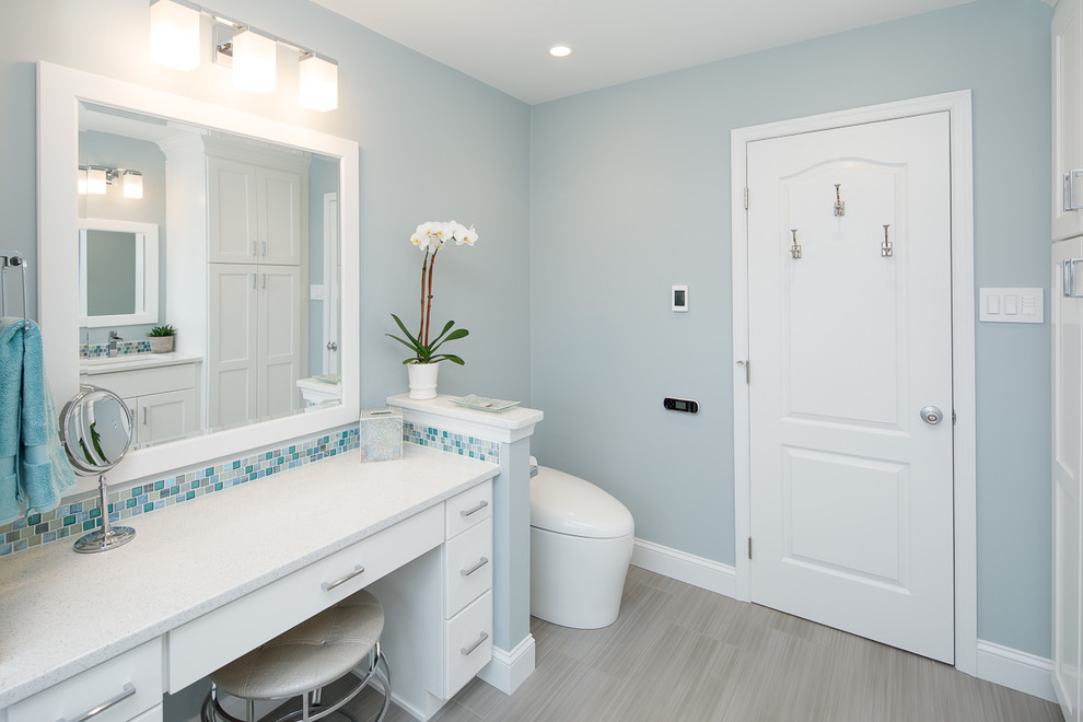 Design ideas for a large coastal wet room bathroom in Philadelphia with flat-panel cabinets, white cabinets, a built-in bath, a bidet, blue tiles, mosaic tiles, blue walls, porcelain flooring, a submerged sink, engineered stone worktops, grey floors, an open shower and white worktops.