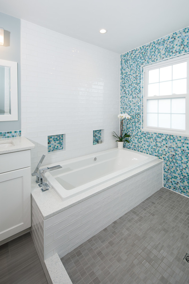 Идея дизайна: большая ванная комната в морском стиле с плоскими фасадами, белыми фасадами, накладной ванной, душевой комнатой, биде, синей плиткой, плиткой мозаикой, синими стенами, полом из керамогранита, врезной раковиной, столешницей из искусственного кварца, серым полом, открытым душем и белой столешницей