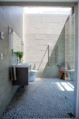 Пример оригинального дизайна: главная ванная комната среднего размера в стиле модернизм с душем без бортиков, биде, серой плиткой, каменной плиткой, серыми стенами, полом из галечной плитки, плоскими фасадами, серыми фасадами, монолитной раковиной, серым полом и открытым душем