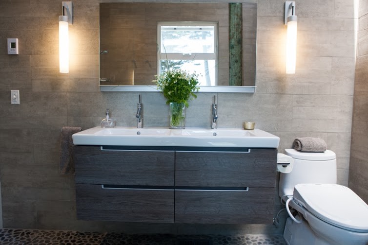 Exemple d'une salle de bain principale moderne de taille moyenne avec une douche à l'italienne, un bidet, un carrelage gris, un carrelage de pierre, un mur gris, un sol en galet, un placard à porte plane, des portes de placard grises, un lavabo intégré, un sol gris et aucune cabine.