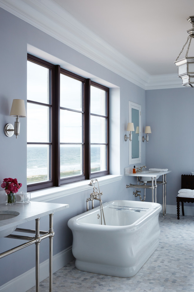 Foto de cuarto de baño principal marinero con lavabo tipo consola, bañera exenta y paredes azules