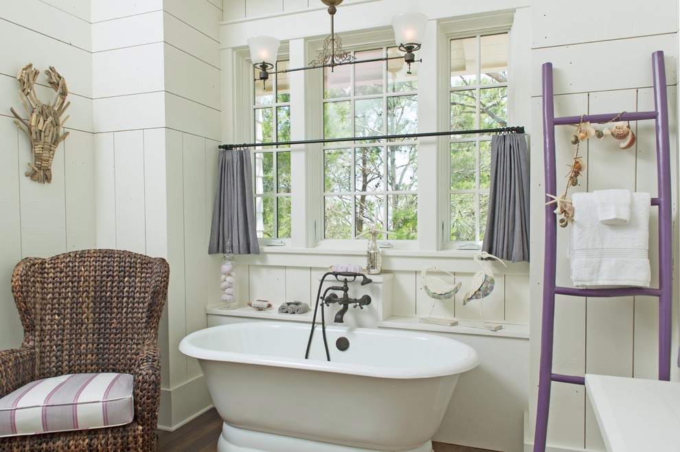 Foto di una stanza da bagno stile marinaro con vasca freestanding, vasca/doccia, pareti bianche, pavimento in legno massello medio, pavimento marrone e doccia aperta