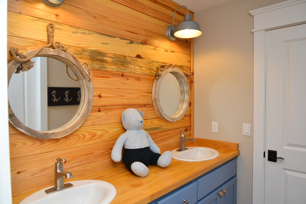 Idéer för mellanstora lantliga badrum för barn, med beige väggar, ett nedsänkt handfat, skåp i shakerstil, blå skåp och träbänkskiva