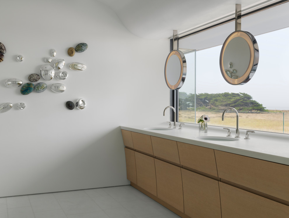 Réalisation d'une salle de bain principale marine en bois clair avec un mur blanc, un sol en carrelage de céramique, un lavabo encastré, un sol blanc, un plan de toilette blanc, meuble double vasque et meuble-lavabo encastré.