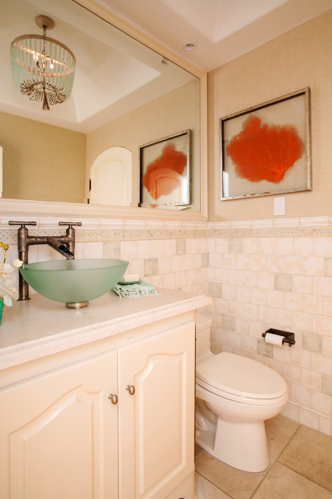 Example of a mid-sized beach style white tile and stone tile travertine floor bathroom design in Orange County with raised-panel cabinets, white cabinets, a two-piece toilet, white walls and a vessel sink