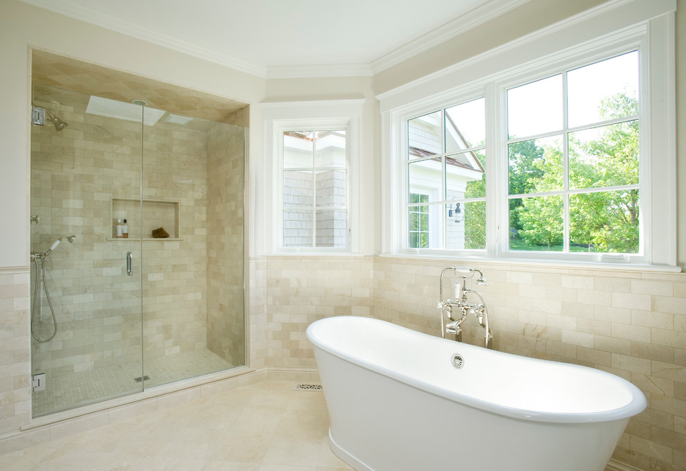 Imagen de cuarto de baño costero con puertas de armario blancas, bañera exenta y baldosas y/o azulejos multicolor