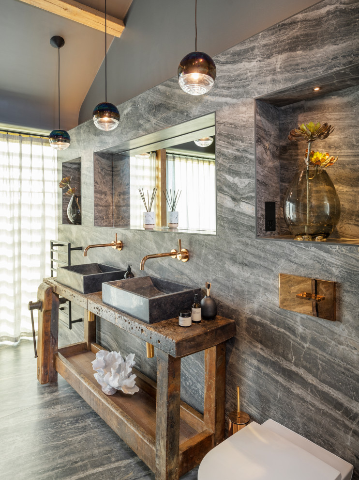 Trendy gray tile gray floor, double-sink, exposed beam and vaulted ceiling bathroom photo in Cornwall with open cabinets, dark wood cabinets, gray walls, a vessel sink, wood countertops, brown countertops and a freestanding vanity