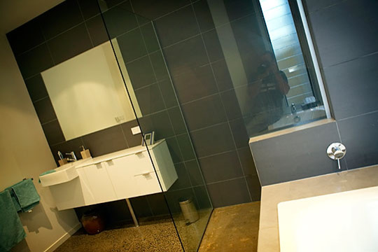 Esempio di una stanza da bagno con doccia stile marino di medie dimensioni con lavabo rettangolare, consolle stile comò, ante bianche, vasca da incasso, doccia aperta, piastrelle grigie, piastrelle in ceramica, pareti grigie e pavimento in cemento