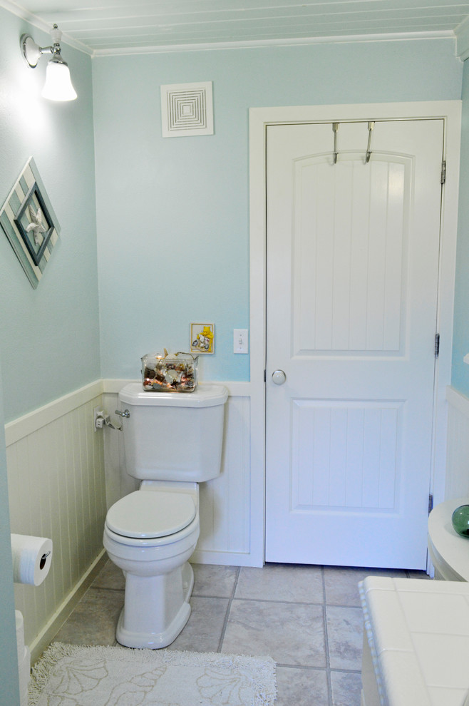 На фото: ванная комната в морском стиле с раздельным унитазом, синими стенами и полом из винила с