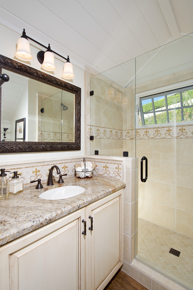 Foto på ett mellanstort vintage badrum med dusch, med ett undermonterad handfat, luckor med upphöjd panel, skåp i slitet trä, granitbänkskiva, gul kakel och mosaik