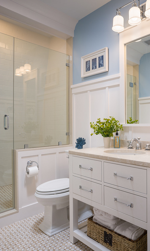 Klassisk inredning av ett badrum, med vita skåp och blå väggar