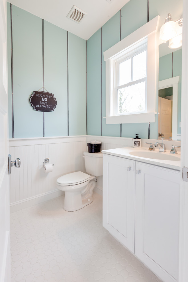 Exempel på ett mellanstort maritimt badrum för barn, med ett integrerad handfat, luckor med infälld panel, vita skåp, bänkskiva i akrylsten, ett fristående badkar, en öppen dusch, en toalettstol med separat cisternkåpa, vit kakel, porslinskakel, blå väggar och klinkergolv i porslin