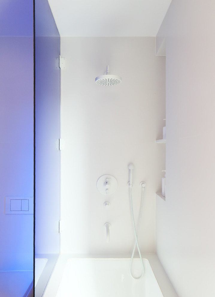 Inspiration pour une petite salle de bain principale minimaliste avec un placard sans porte, des portes de placard blanches, une baignoire posée, WC suspendus, un carrelage blanc, des carreaux de céramique, un mur blanc, un sol en carrelage de céramique, un lavabo encastré et un plan de toilette en quartz.