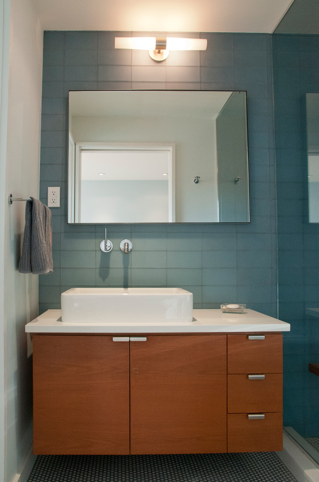 Aménagement d'une salle de bain moderne en bois brun avec une vasque, un placard à porte plane, un plan de toilette en verre recyclé, une douche double, WC à poser, un carrelage beige et un carrelage en pâte de verre.
