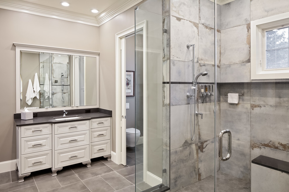 Example of a large transitional master multicolored tile and porcelain tile porcelain tile and gray floor double shower design in Other with furniture-like cabinets, gray cabinets, a wall-mount toilet, gray walls, an undermount sink, granite countertops, a hinged shower door and black countertops