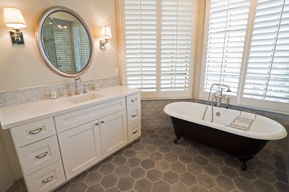Example of a transitional master gray tile and cement tile concrete floor claw-foot bathtub design in Other with an undermount sink, shaker cabinets, white cabinets, quartz countertops, a two-piece toilet and gray walls