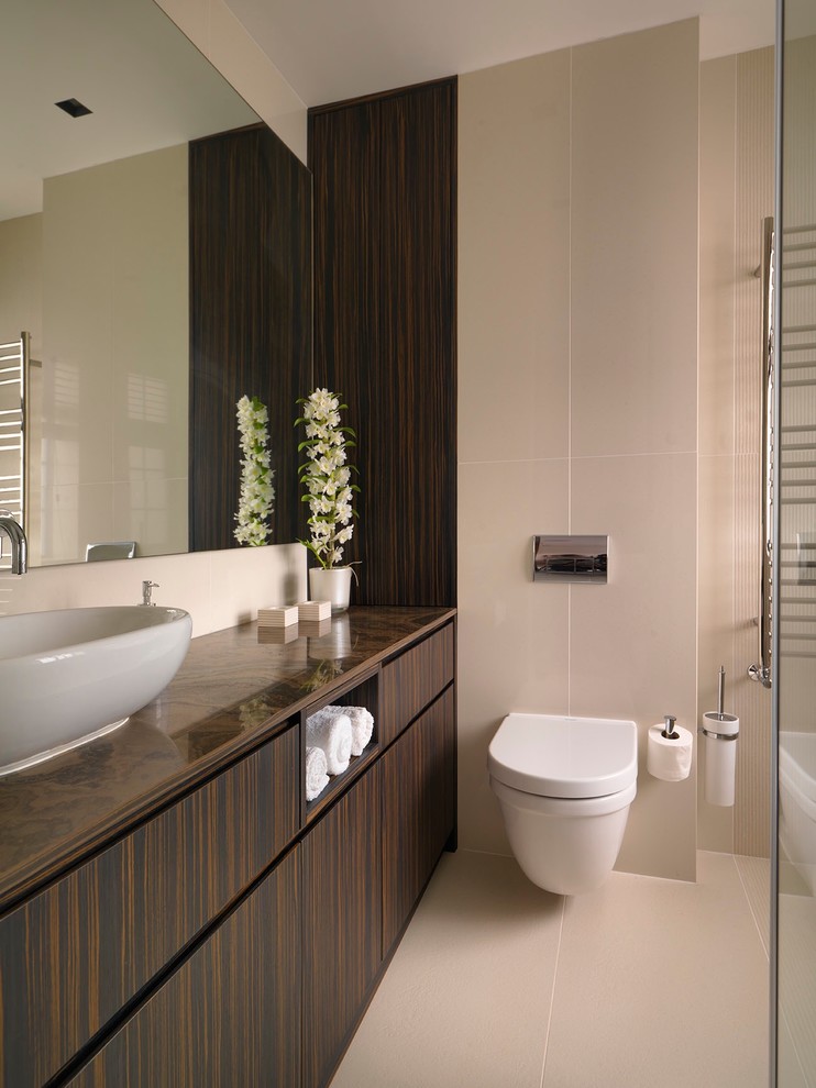 Пример оригинального дизайна: ванная комната в современном стиле с настольной раковиной, плоскими фасадами, темными деревянными фасадами, инсталляцией, бежевой плиткой и коричневой столешницей