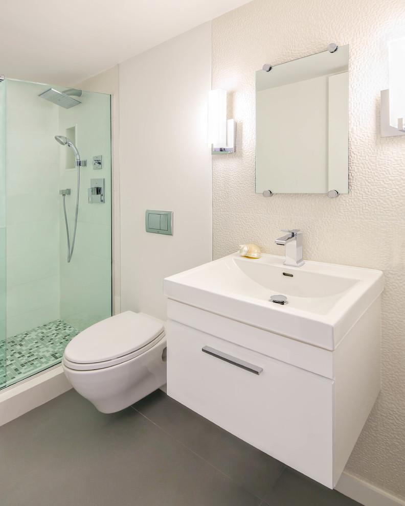 Ispirazione per una piccola stanza da bagno minimalista con lavabo integrato, ante lisce, ante bianche, WC sospeso, piastrelle multicolore, piastrelle di vetro, pareti bianche e pavimento in gres porcellanato
