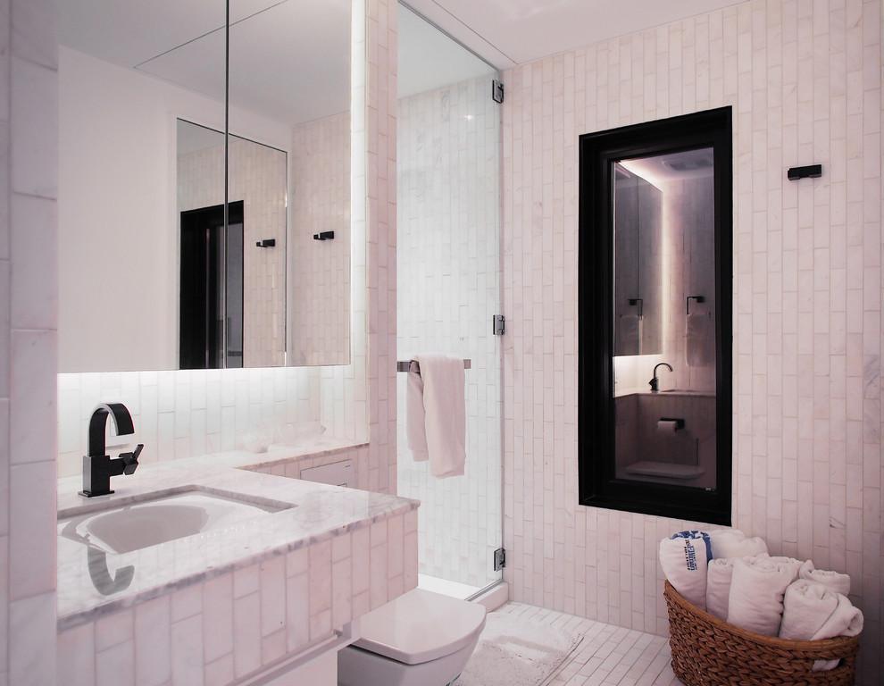 Inspiration for a small contemporary ensuite bathroom in New York with flat-panel cabinets, white cabinets, an alcove shower, a wall mounted toilet, white tiles, mosaic tiles, yellow walls, marble flooring, a submerged sink and marble worktops.
