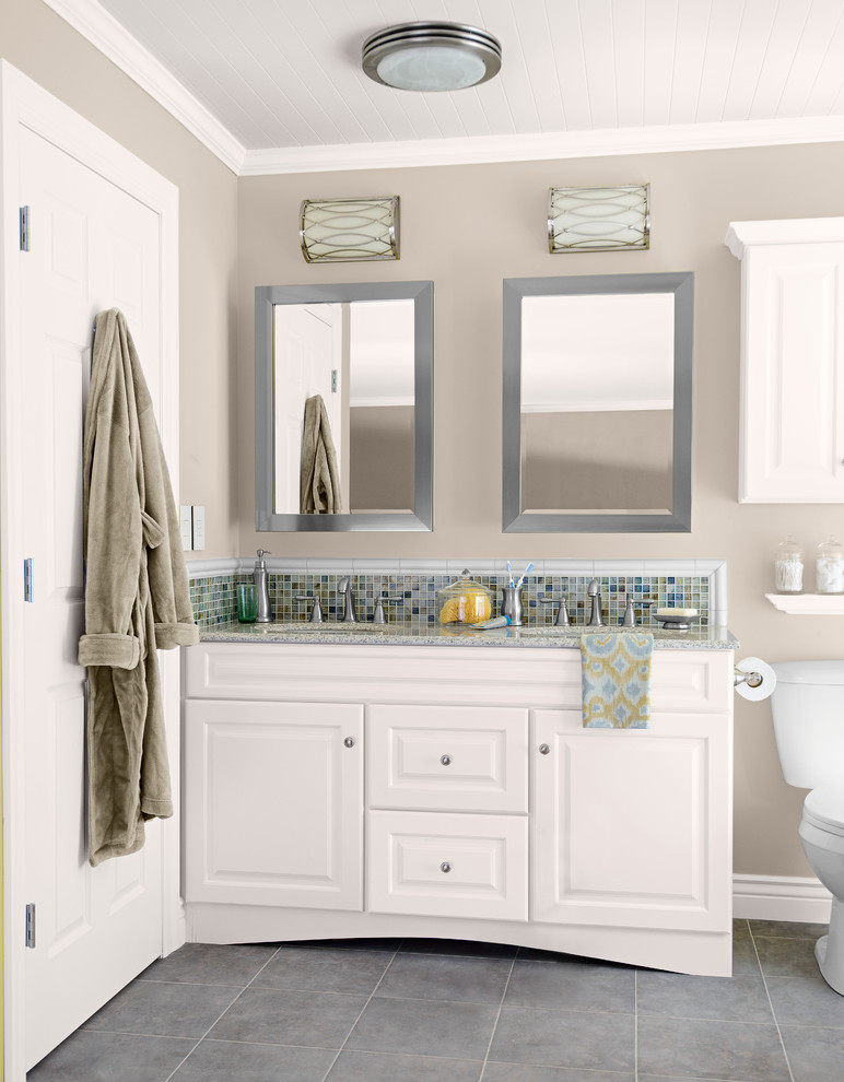 Inredning av ett klassiskt mellanstort en-suite badrum, med ett undermonterad handfat, luckor med upphöjd panel, vita skåp, granitbänkskiva, en toalettstol med separat cisternkåpa, flerfärgad kakel, mosaik, grå väggar och klinkergolv i keramik