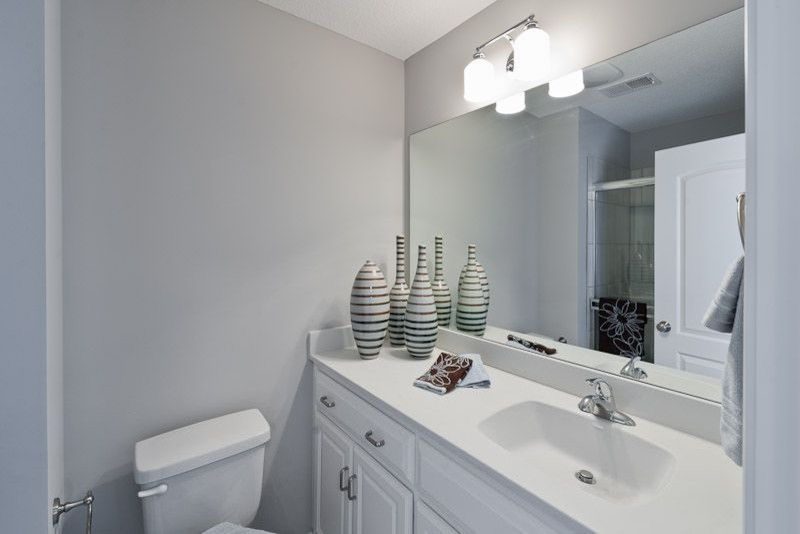 Esempio di una stanza da bagno con doccia classica di medie dimensioni con ante in stile shaker, ante bianche, top in superficie solida e porta doccia scorrevole