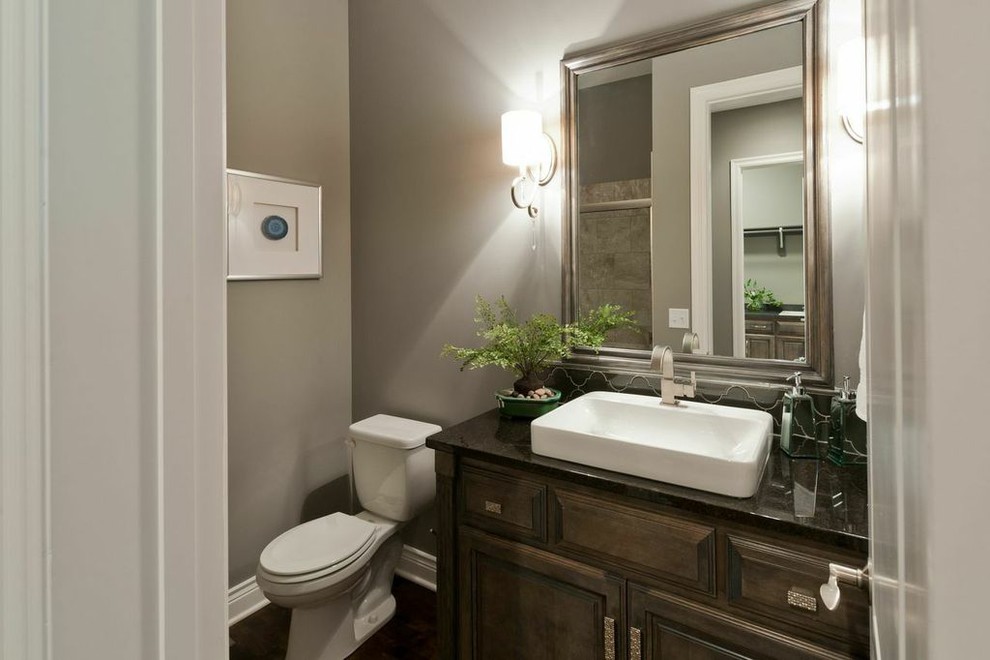 Cette photo montre une salle d'eau en bois brun de taille moyenne avec un placard à porte shaker, des carreaux de céramique et un plan de toilette en marbre.