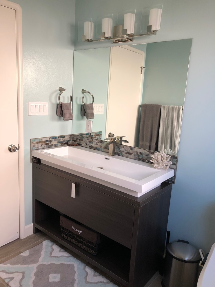 Foto på ett litet amerikanskt vit badrum för barn, med släta luckor, bruna skåp, ett badkar i en alkov, en toalettstol med separat cisternkåpa, blå väggar, klinkergolv i porslin, ett integrerad handfat, bänkskiva i akrylsten, brunt golv och dusch med duschdraperi