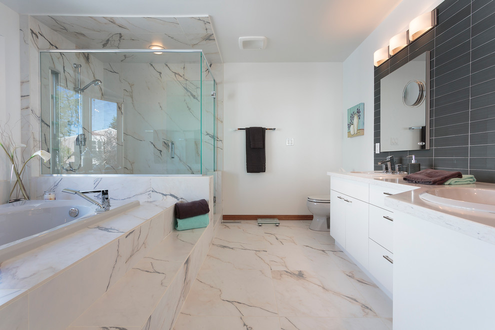 Inspiration for a large timeless master black tile, gray tile and glass tile marble floor bathroom remodel in Other with flat-panel cabinets, white cabinets, a two-piece toilet, white walls, a drop-in sink and solid surface countertops