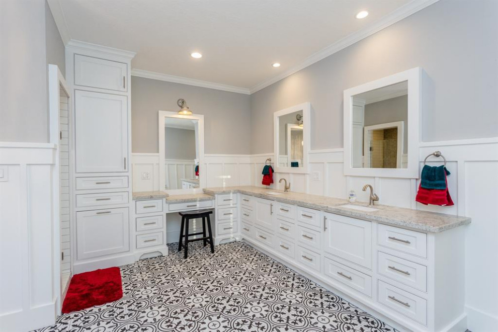 На фото: большая главная, серо-белая ванная комната в стиле модернизм с фасадами в стиле шейкер, белыми фасадами, отдельно стоящей ванной, угловым душем, унитазом-моноблоком, белой плиткой, полом из керамической плитки, врезной раковиной, столешницей из гранита, разноцветным полом, душем с распашными дверями, серой столешницей, тумбой под две раковины, встроенной тумбой, сводчатым потолком, панелями на стенах и серыми стенами с