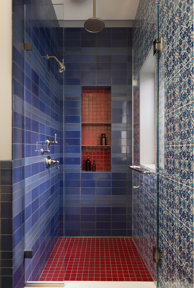 Cette image montre une grande salle de bain traditionnelle avec un carrelage bleu, des carreaux de céramique, un sol en carrelage de céramique, une douche à l'italienne, un mur multicolore, un sol rouge et une cabine de douche à porte battante.