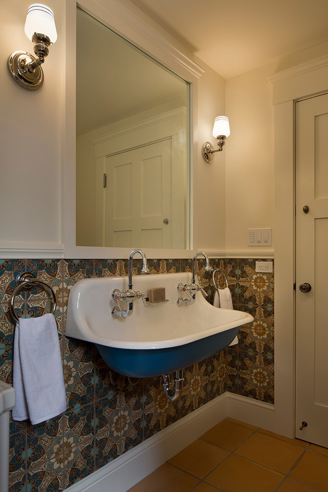 Aménagement d'une salle de bain éclectique avec un carrelage multicolore, un mur blanc, tomettes au sol, un lavabo suspendu et un sol marron.
