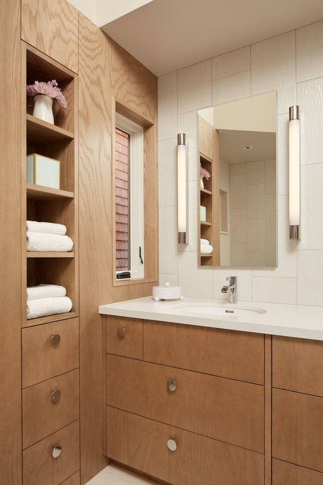 Réalisation d'une salle de bain tradition en bois brun avec un lavabo encastré, un placard à porte plane, un mur blanc et un carrelage blanc.