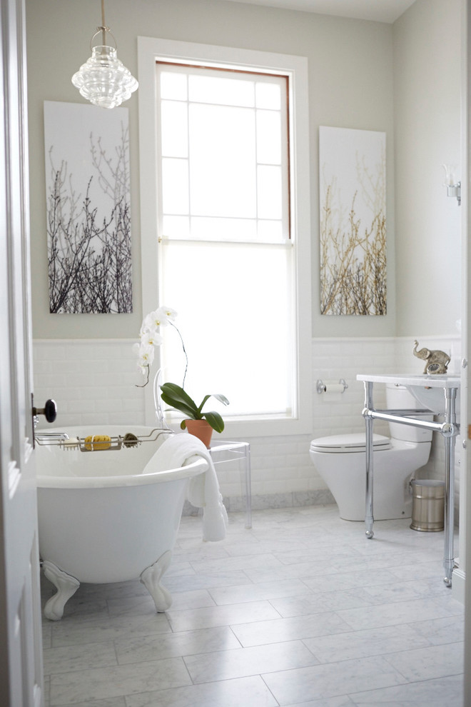 Cette image montre une salle de bain principale traditionnelle de taille moyenne avec un plan de toilette en marbre, une baignoire sur pieds, une douche d'angle, un carrelage blanc, un carrelage métro, un mur gris, un sol en marbre, WC séparés et un plan vasque.