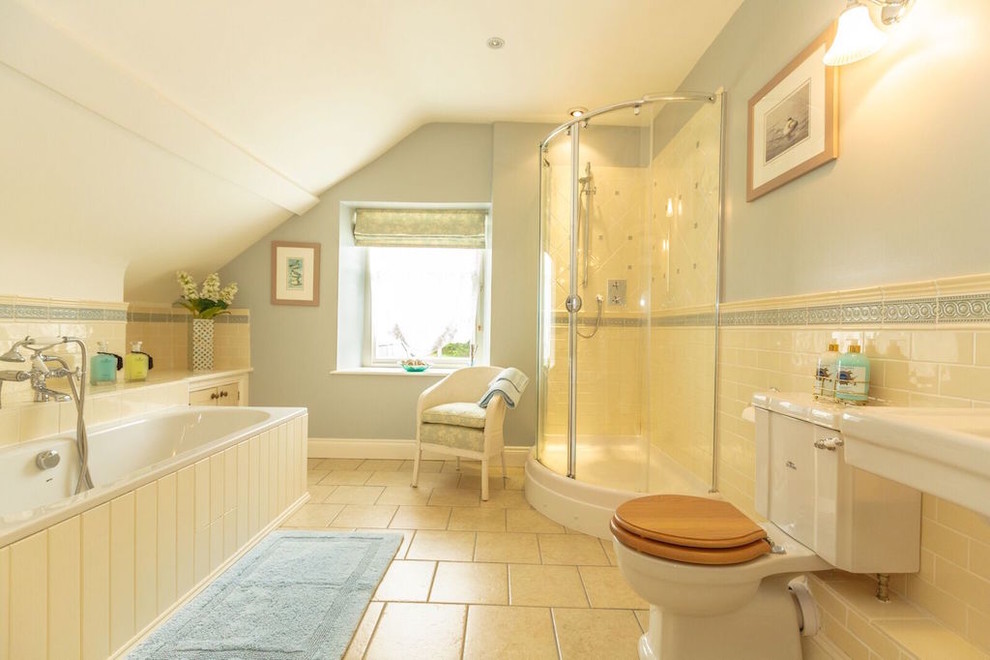 На фото: главная ванная комната в стиле кантри с накладной ванной, угловым душем, раздельным унитазом, бежевой плиткой, синими стенами, бежевым полом и душем с раздвижными дверями