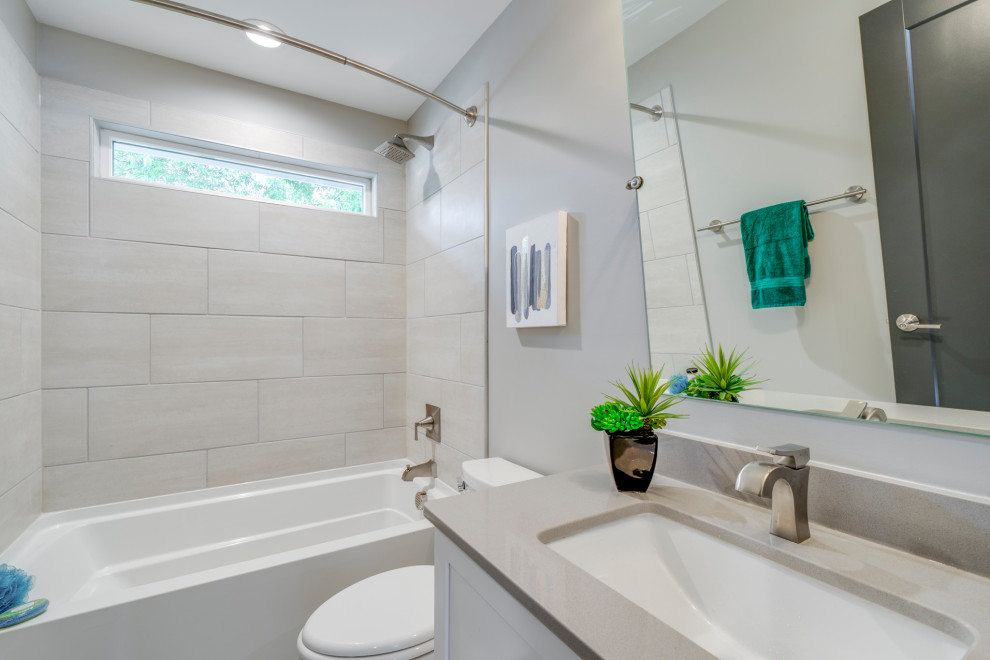 Mid-sized arts and crafts kids' gray tile and ceramic tile ceramic tile and gray floor bathroom photo in Raleigh with shaker cabinets, white cabinets, a one-piece toilet, gray walls, an undermount sink, quartz countertops and white countertops