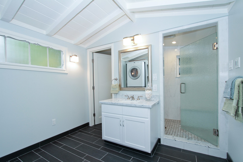 Exempel på ett mellanstort maritimt en-suite badrum, med ett undermonterad handfat, släta luckor, vita skåp, marmorbänkskiva, vit kakel, blå väggar och klinkergolv i porslin