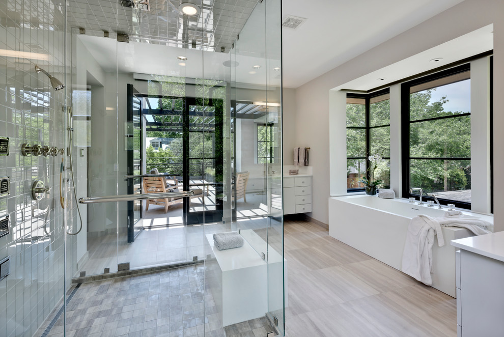 Идея дизайна: ванная комната в современном стиле с плоскими фасадами, белыми фасадами, отдельно стоящей ванной, серой плиткой и сиденьем для душа