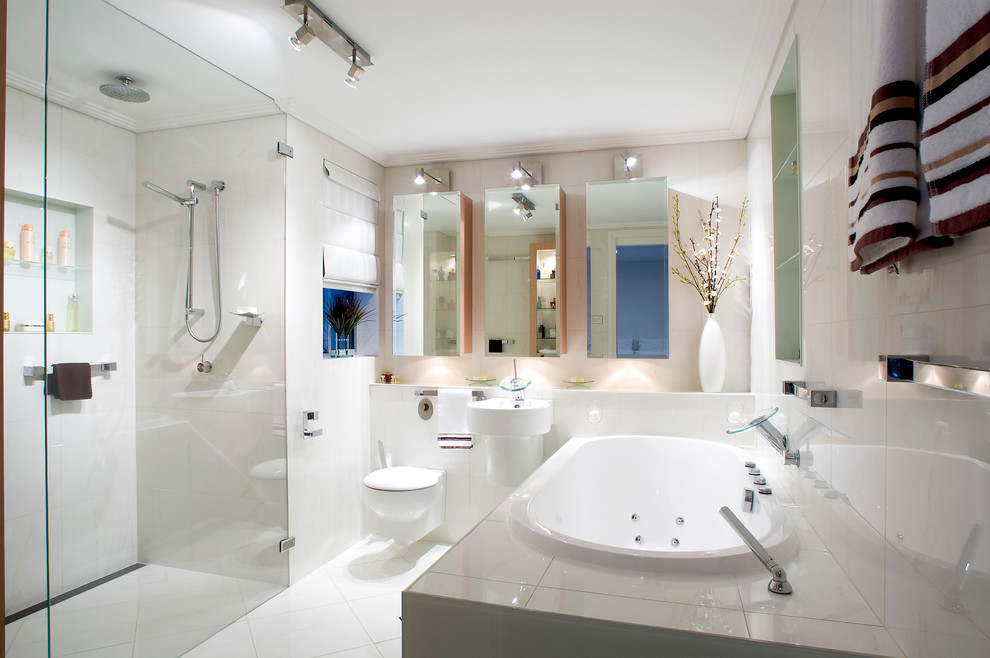 Foto di una stanza da bagno padronale contemporanea di medie dimensioni con vasca sottopiano, doccia a filo pavimento, piastrelle bianche, pareti bianche e WC sospeso