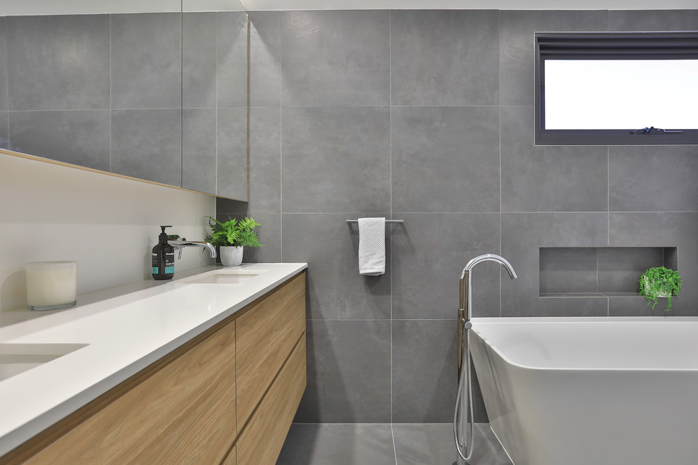 Großes Modernes Badezimmer En Suite mit flächenbündigen Schrankfronten, hellen Holzschränken, freistehender Badewanne, weißen Fliesen, Keramikfliesen, grauer Wandfarbe, Keramikboden, Quarzwerkstein-Waschtisch, grauem Boden und weißer Waschtischplatte in Sydney