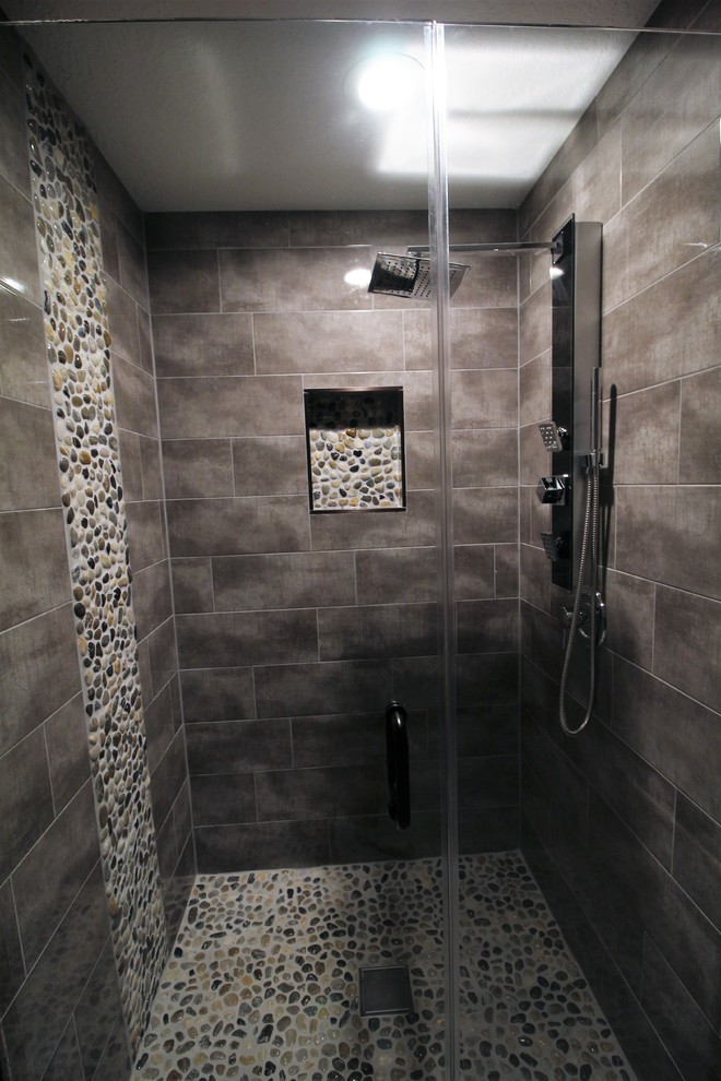 Foto på ett mellanstort vintage vit badrum med dusch, med luckor med lamellpanel, svarta skåp, ett fristående badkar, en dusch i en alkov, grå kakel, porslinskakel, beige väggar, klinkergolv i porslin, ett undermonterad handfat, bänkskiva i akrylsten, vitt golv och dusch med gångjärnsdörr