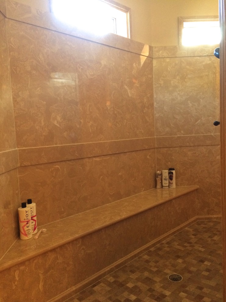 Exemple d'une grande salle de bain principale chic en bois foncé avec un lavabo encastré, un placard en trompe-l'oeil, un plan de toilette en surface solide, un bain bouillonnant, une douche ouverte, un carrelage beige, un carrelage de pierre, un mur beige et un sol en carrelage de porcelaine.